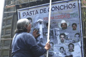 Family members hang a poster to remember Pasta de conchos mine workers killed in gas explosion