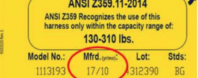 Safety harness tag showing compliance dates